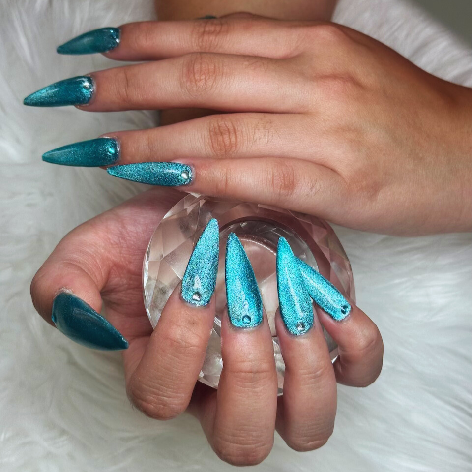 Glittery turquoise stiletto shaped gel nail extensions